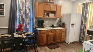 A compact kitchen with wooden cabinets, a coffee maker, a blender, and a refrigerator. - Cozy and stylish apartment in central meriden (Meriden)