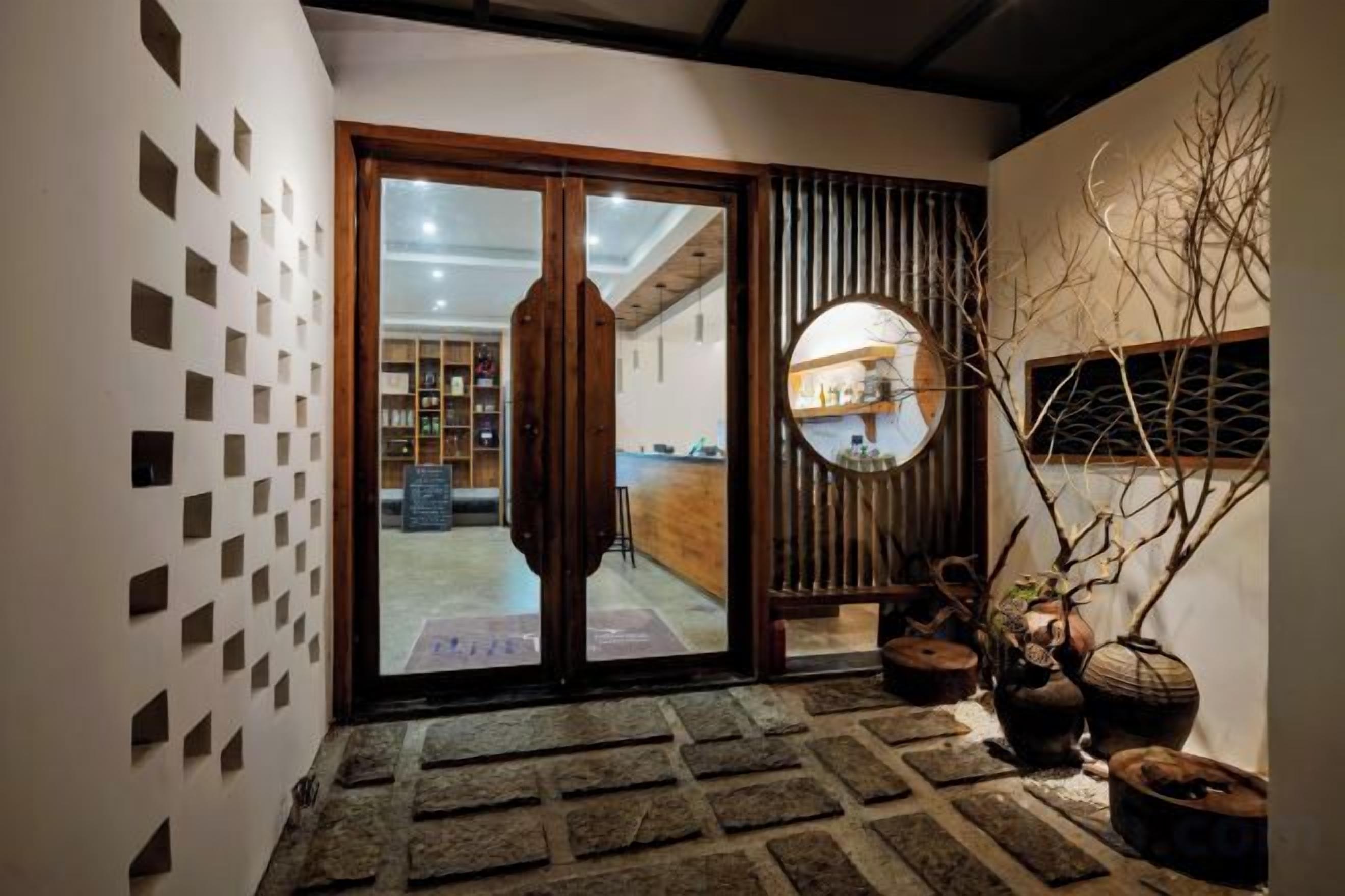 A reception area with a sliding glass door, a reception desk, and a wall with square patterns.