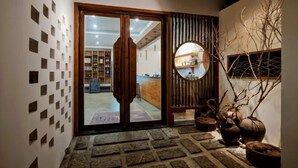 A traditional Japanese-style entrance with a sliding door, stone steps, and a wooden panel wall. - Mini Inn (Zhangjiajie)