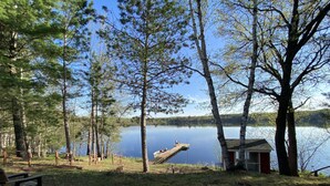 Un chalet au bord du lac, doté d’une jetée qui s’avance sur l’eau, et entouré d’arbres.