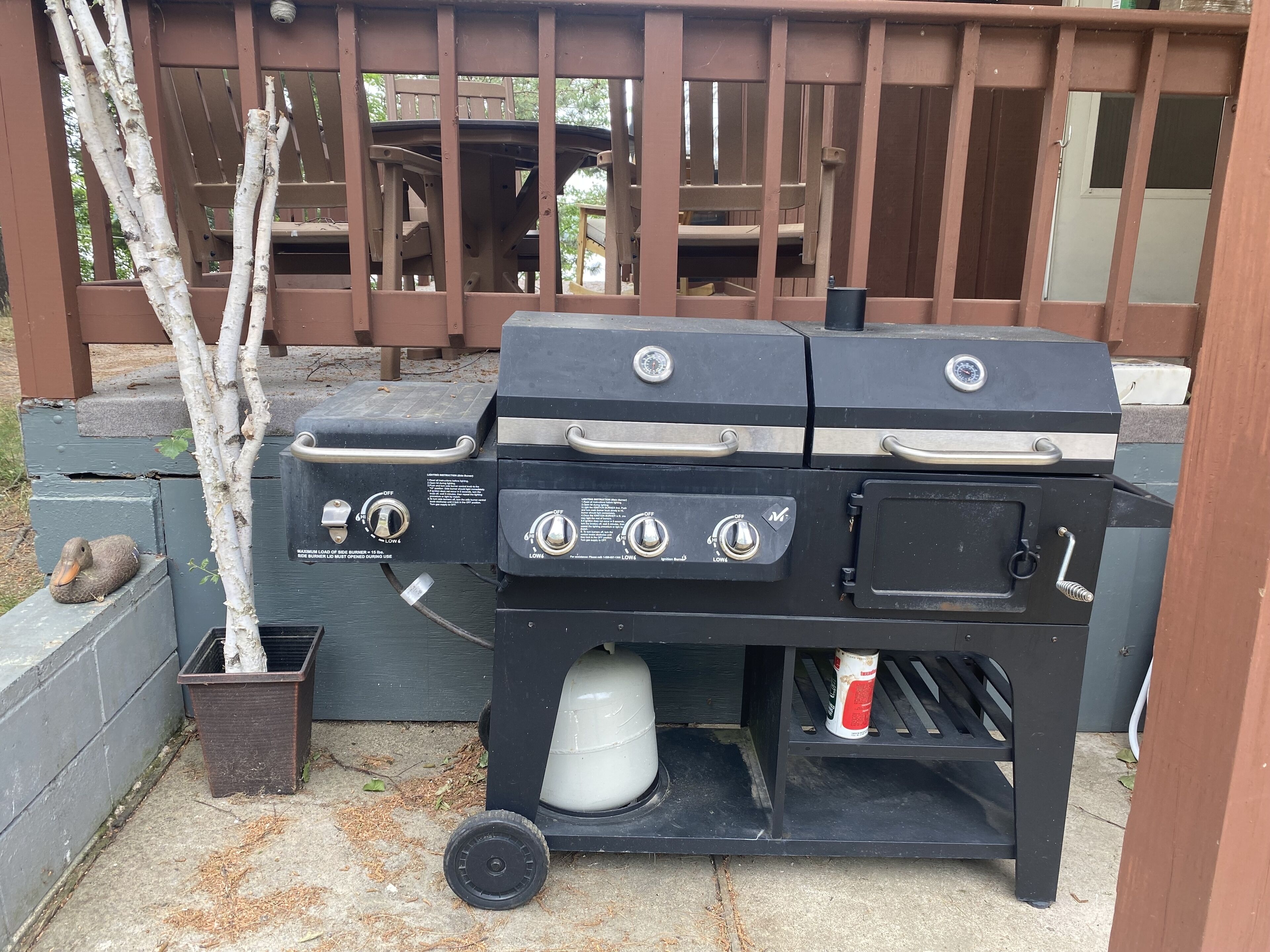 Een barbecue met twee branders, een waterreservoir en een blik aansteker.