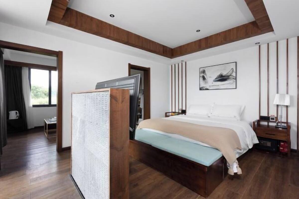 Un dormitorio moderno con cama, mesita de noche y un cuadro en la pared.