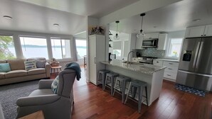 A modern kitchen with a large island, stainless steel appliances, and a view of the outdoors. - Beautiful lakefront property on Barton Lake with Hot Tub! (Vicksburg)