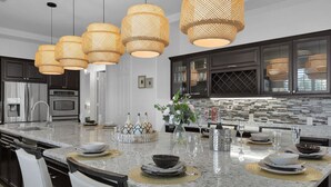Uma cozinha moderna com uma ilha grande, eletrodomésticos de aço inoxidável e uma decoração de parede chamativa.