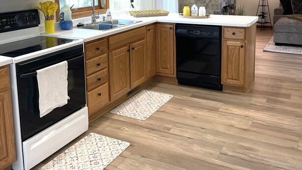 Una cocina moderna con armarios de madera, microondas integrado, horno y lavavajillas.