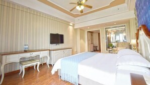 A hotel room with a large bed, a desk with a chair, a television, and a ceiling fan. - Laiya Boutique Hotel (Southwest University Zhuangyuanbei Subway Station) (Chongqing)