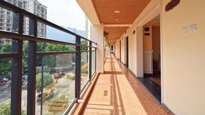 A corridor with large windows, a wooden ceiling, and a view of a cityscape. - Laiya Boutique Hotel (Southwest University Zhuangyuanbei Subway Station) (Chongqing)