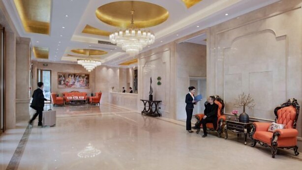 Un lobby espacioso con techo alto, elegantes candelabros y zonas de estar confortables.