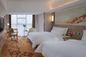 A hotel room with two beds, a desk with a laptop, a TV, and a window with curtains. - Vienna International Hotel (Shaoyang Dahan Pedestrian Street) (Shaoyang)