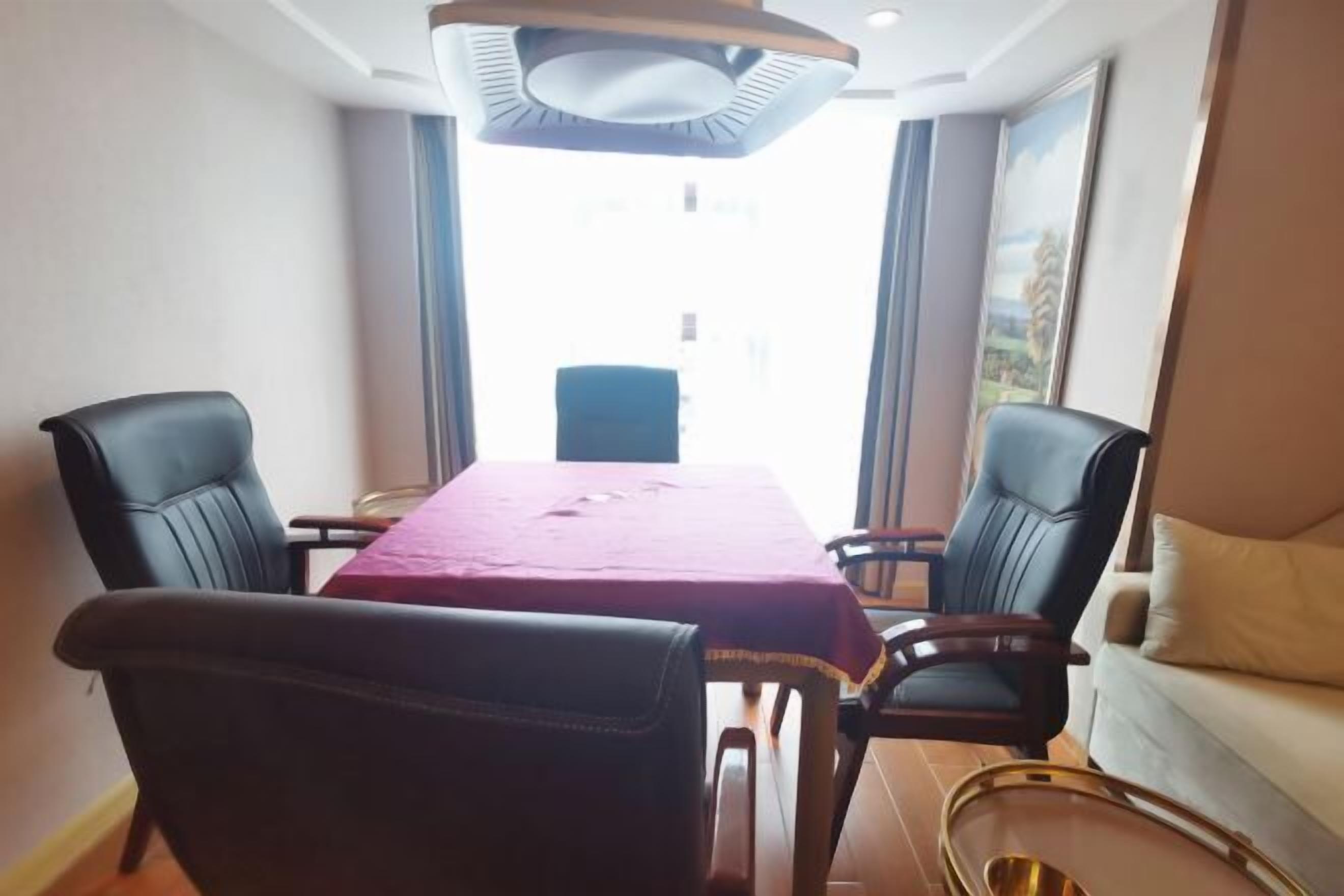 A dining area with a table, chairs, and a sofa.