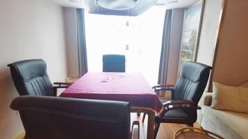 A dining area with a table, chairs, and a sofa.