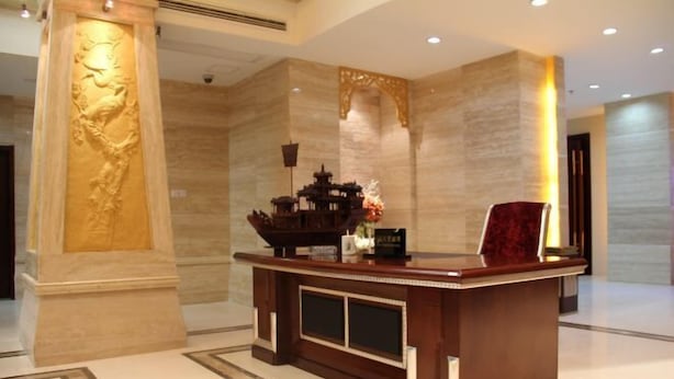 A reception desk with a traditional design, a large pillar with an intricate carving, and a decorative archway. - Sanqingshan Huake Villa (East Jinsha Cableway Branch) (Yushan)