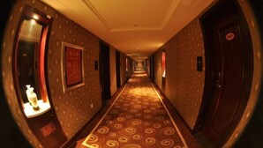 A hotel hallway with patterned carpet, doors on both sides, and framed signs on the walls. - Sanqingshan Huake Villa (East Jinsha Cableway Branch) (Yushan)
