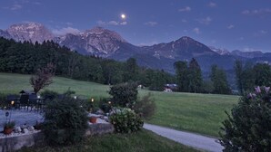 A mountain landscape with a clear sky and a visible moon.
