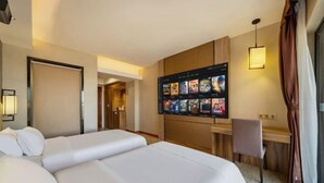 A hotel room with a large bed, a desk with a computer, and a TV displaying movie posters. - Foshan Leshui Mansion (Leliu Port West Road Branch) (Foshan)
