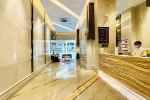 A hotel reception area with a marble floor, a reception desk, and a digital display. - Foshan Leshui Mansion (Leliu Port West Road Branch) (Foshan)