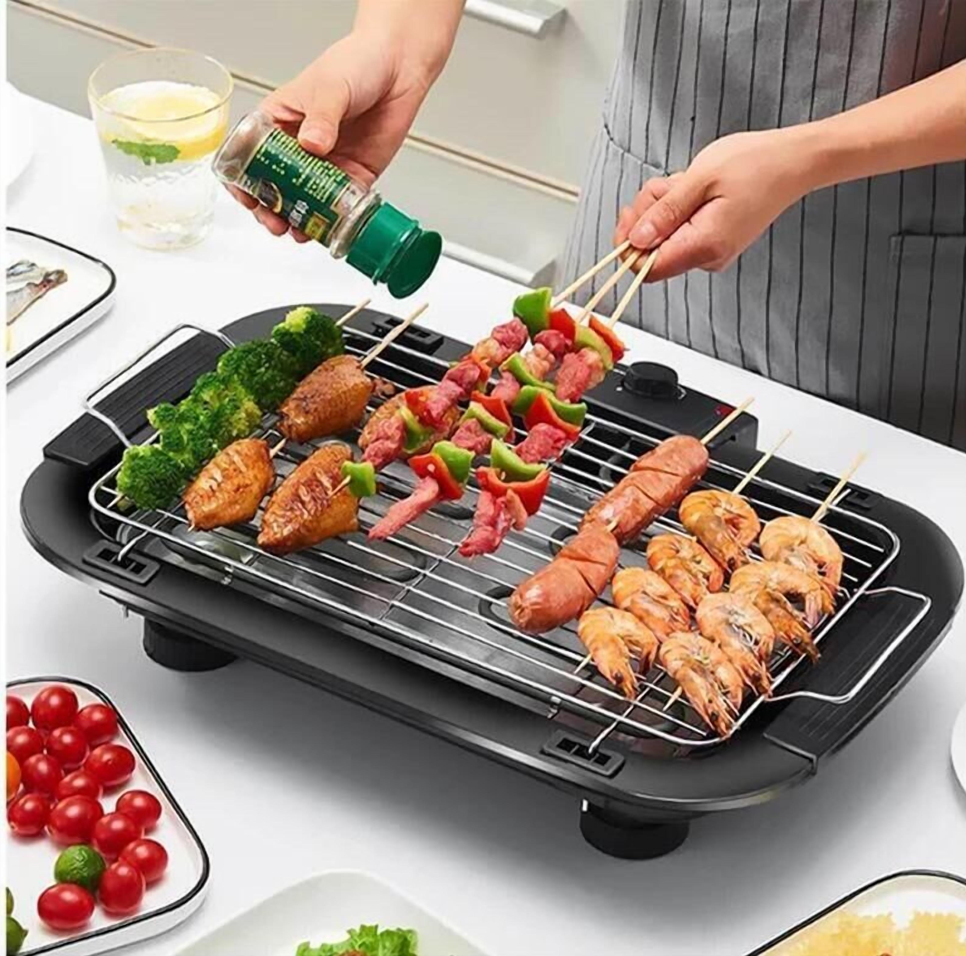 A portable grill with skewers of meat, vegetables, and shrimp being cooked.