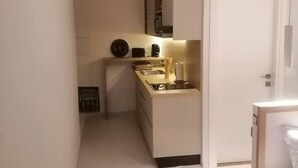 A compact kitchen with white cabinetry, a countertop, and a sink. There is a small window providing natural light. - Charming and Luminous Studio in Lake 1, Tunis (Tunis)