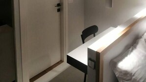 A room with a white door, a desk with a chair, and a pendant light. - Charming and Luminous Studio in Lake 1, Tunis (Tunis)