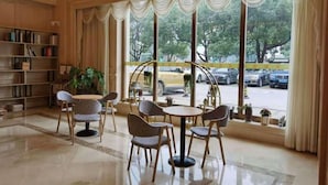 Un hall d’entrée spacieux, doté d’une grande fenêtre, d’un coin salon et d’une bibliothèque.
