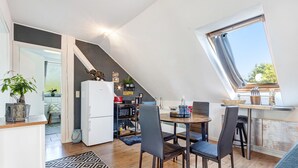 Une cuisine compacte comprenant un coin repas, un réfrigérateur et une fenêtre donnant sur un paysage agréable.