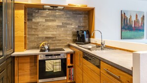 A modern kitchen with a brick backsplash, built-in oven, and a coffee maker. - Apartment 'Gästehaus Wüpping 2' with Shared Terrace, Shared Garden and Wi-Fi (Salem)