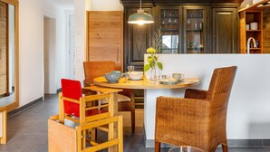 A modern kitchen with wooden cabinets, a dining table with wicker chairs, and a pendant light. - Apartment 'Gästehaus Wüpping 2' with Shared Terrace, Shared Garden and Wi-Fi (Salem)