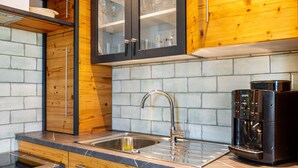 A modern kitchen with a stainless steel sink, wooden cabinets, and a built-in coffee machine. - Apartment 'Gästehaus Wüpping 1' with Shared Terrace, Shared Garden and Wi-Fi (Salem)