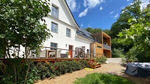A two-story house with a balcony, a wooden deck, and a garden area. - Apartment 'Gästehaus Wüpping 1' with Shared Terrace, Shared Garden and Wi-Fi (Salem)