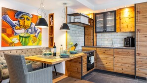 A modern kitchen with a wooden island, built-in appliances, and a dining area with a cushioned bench. - Apartment 'Gästehaus Wüpping 1' with Shared Terrace, Shared Garden and Wi-Fi (Salem)