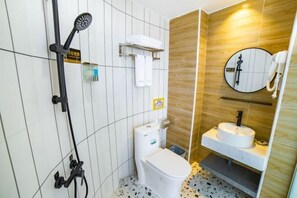 A bathroom with a toilet, sink, and shower.