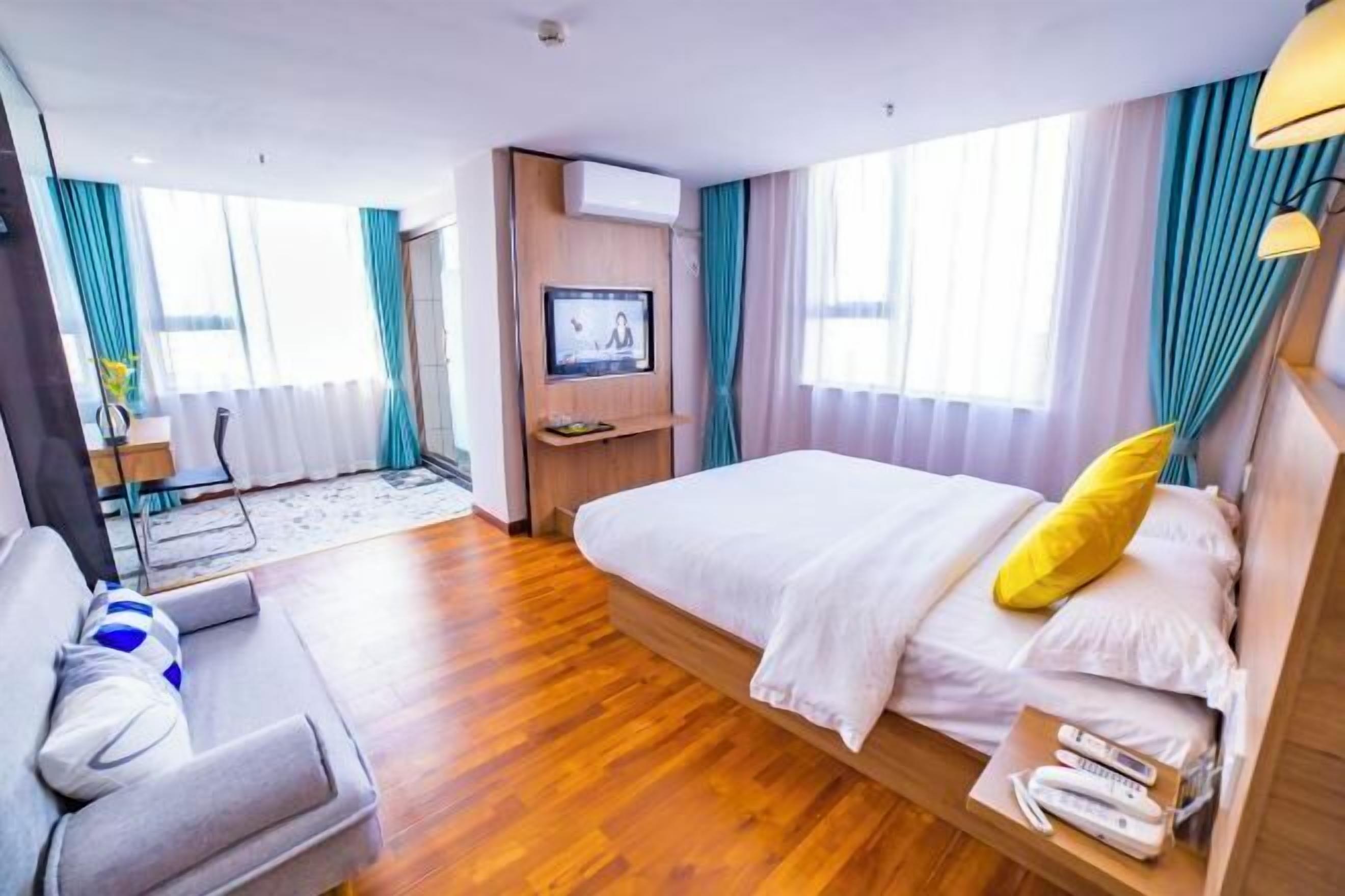 Une chambre d’hôtel avec un lit, une télévision, un bureau et une chaise.
