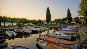 A marina with various boats docked, surrounded by trees and buildings. - Henry-Historic Center 300m From Lake, San Felice del Benaco, Italy (San Felice del Benaco)