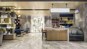 A modern interior with a reception desk, seating area, and bookshelves. - Echarm Hotel (Chongzuo Youyi Avenue South Railway Station) (Chongzuo)