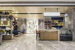 A modern interior with a reception desk, seating area, and bookshelves.