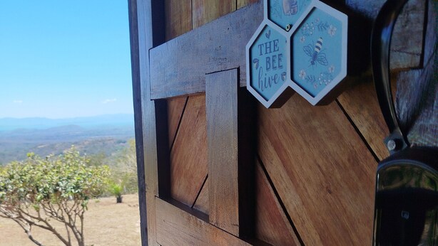 Une porte en bois sur laquelle est fixée une enseigne hexagonale portant l’inscription « THE BEE HIVE ».