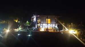 Un immeuble de deux étages doté d’un balcon et d’une entrée éclairée.