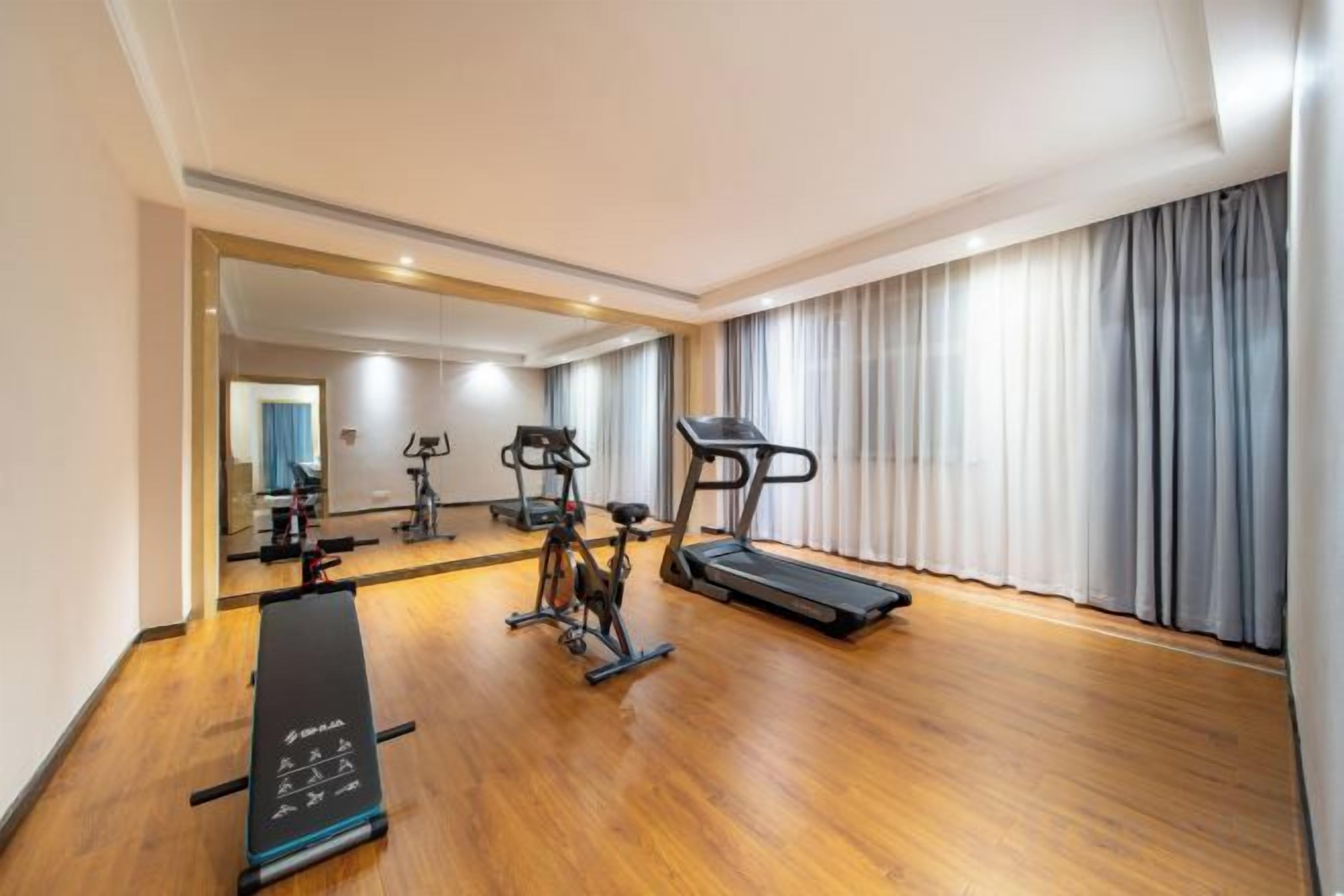 A gym with exercise equipment including a treadmill, elliptical, and stationary bike.