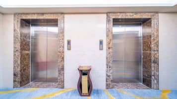 An elevator with marble walls and a carpeted floor.