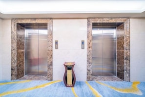An elevator with marble walls and a carpeted floor.