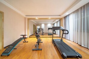 A gym with treadmills, stationary bikes, and a rowing machine. - Boyu Hotel (Karamay)