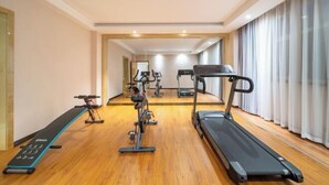A gym with treadmills, stationary bikes, and a rowing machine. - Boyu Hotel (Karamay)