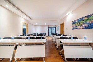 A conference room with multiple tables and chairs, equipped with water bottles and nameplates. - Boyu Hotel (Karamay)