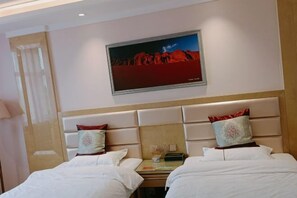 A hotel room with two beds, a small table, and a painting on the wall. - Boyu Hotel (Karamay)