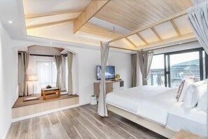 A modern hotel room with a large bed, a television, a desk, and a balcony with a view. - Lanhu Xiaozhu Hostel (Suzhou)