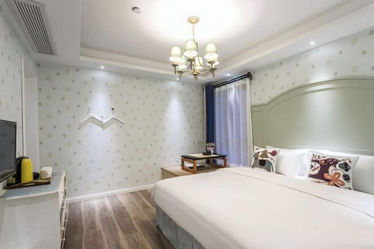 Habitació d'hotel amb llit, taula de nit, televisió i un penjall.