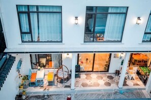 A two-story building with a ground-floor café, outdoor seating, and a visible interior on the second floor. - Lanhu Xiaozhu Hostel (Suzhou)