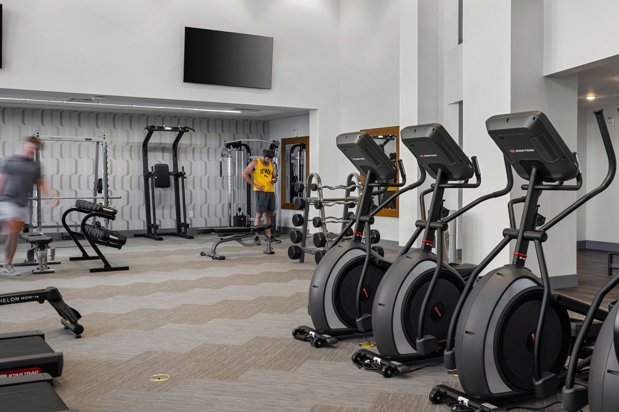 A gym with treadmills, elliptical machines, and weight equipment.