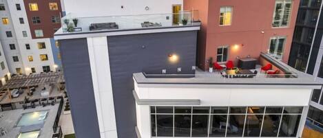Ein modernes Gebäude mit Dachterrasse, Außenbereich zum Sitzen und einem Pool.