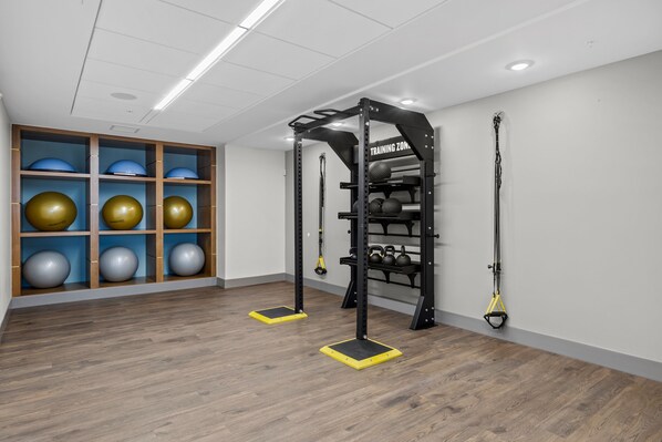 Een sportschool met een optrekstang, gewichtsschijven en weerstandsbanden.